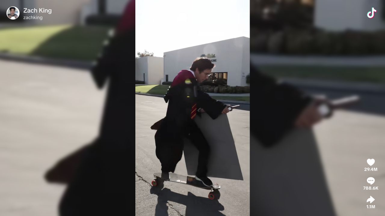 Zach King in a wizard-style outfit appearing to ride a broom along a road.